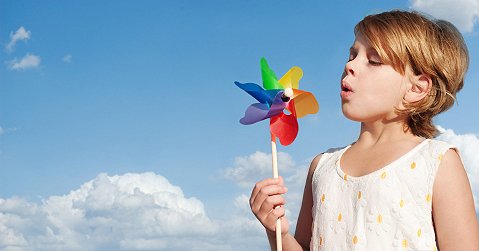 image of little girl blowing a pinwheel